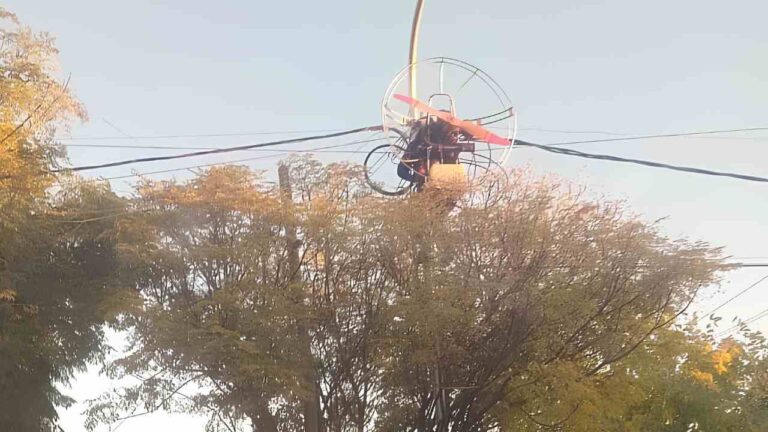 Parapente enganchado en poste de luz